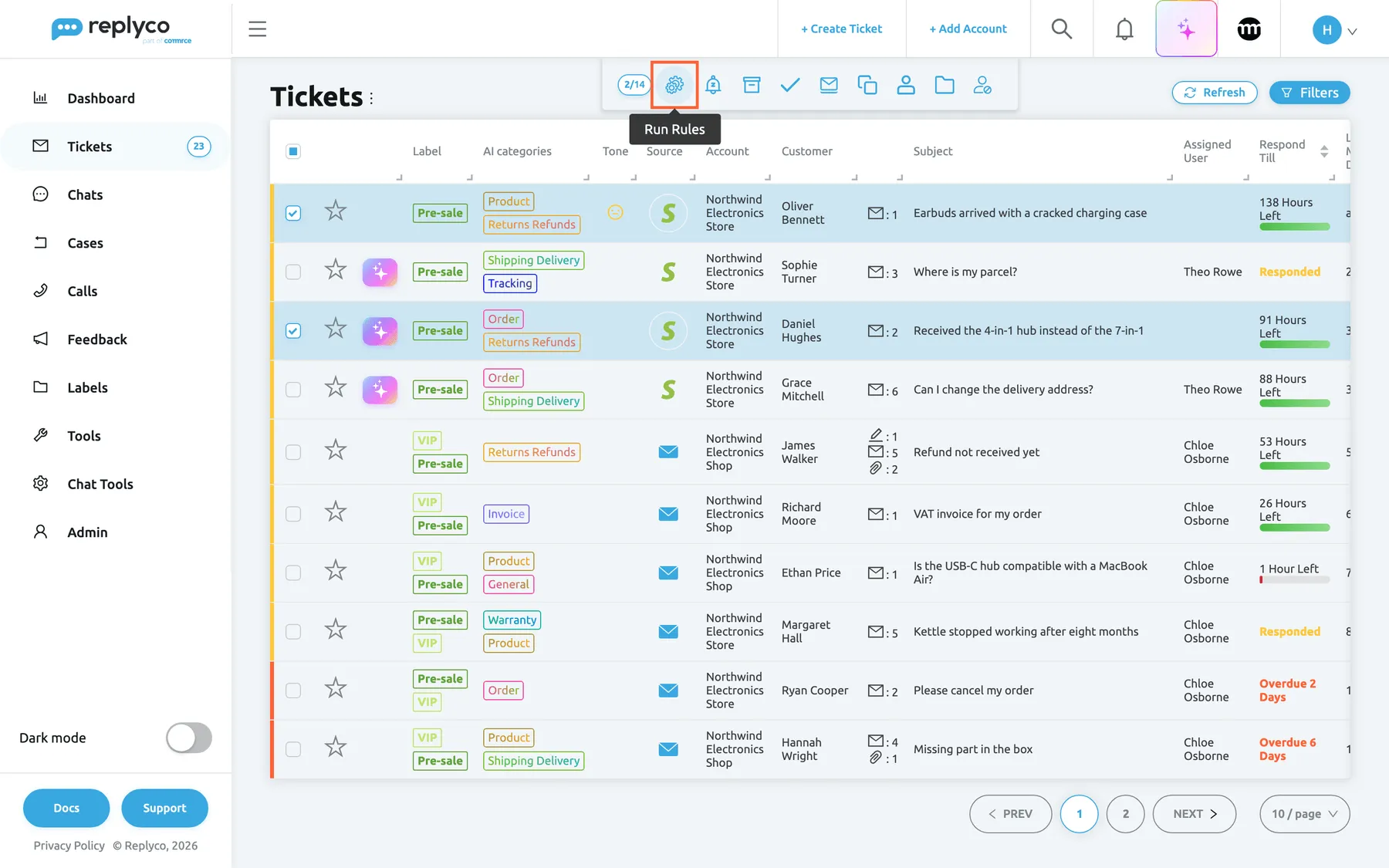 The Not Resolved ticket list with two tickets ticked, "Earbuds arrived with a cracked charging case" from Oliver Bennett and "Received the 4-in-1 hub instead of the 7-in-1" from Daniel Hughes. In the bulk action bar at the top, after the counter 2/14, the gear icon is highlighted and its tooltip reads "Run Rules". It runs every switched-on rule, in the order of the Rules tab, on the latest message of each ticked ticket, which is how new or changed rules reach tickets that are already there.